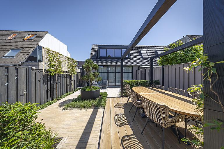 Millboard vlonder in golden oak naast plantenbak met Pinus mugo mughus
